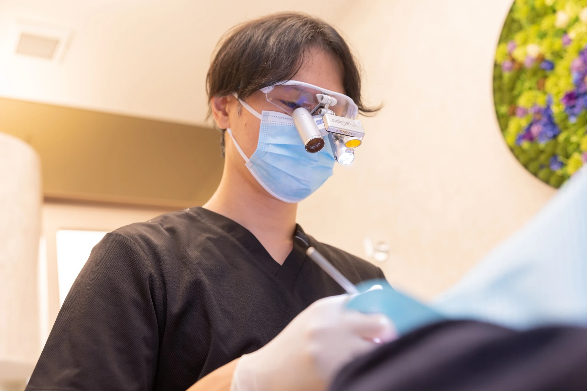 拡大鏡を装着して処置を行う理事長